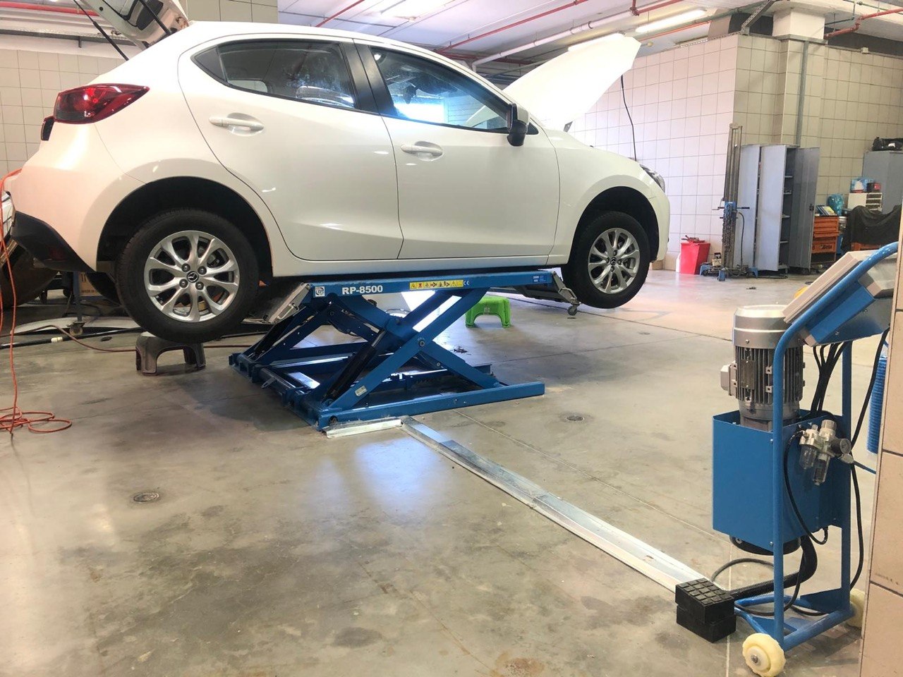 BMW Z4 elevated on tall blue scissor lift